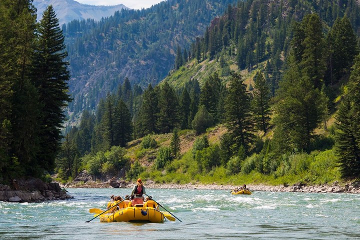 a small boat in a body of water with a mountain in the background