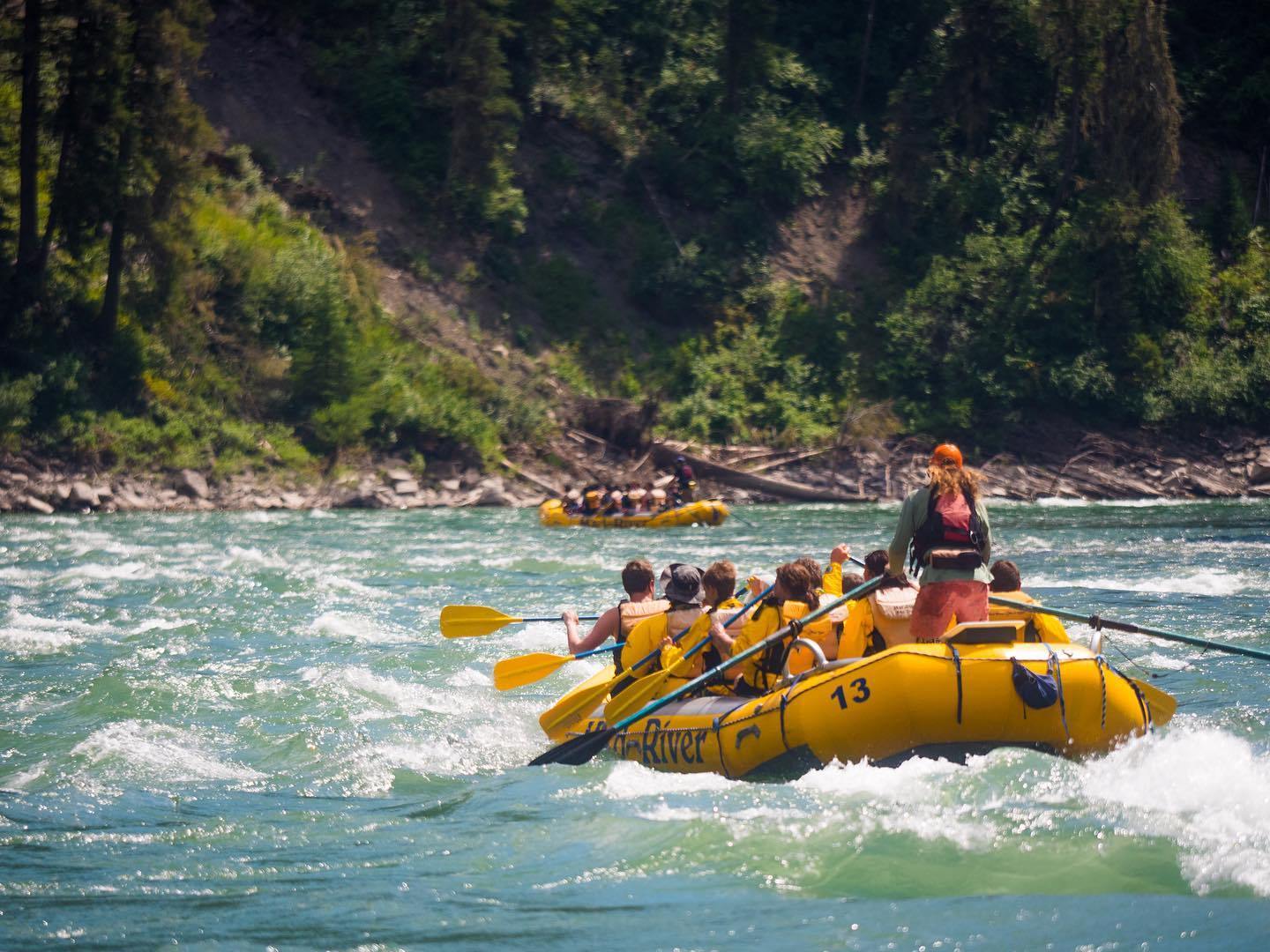 a group of people riding on the back of a boat in the water
