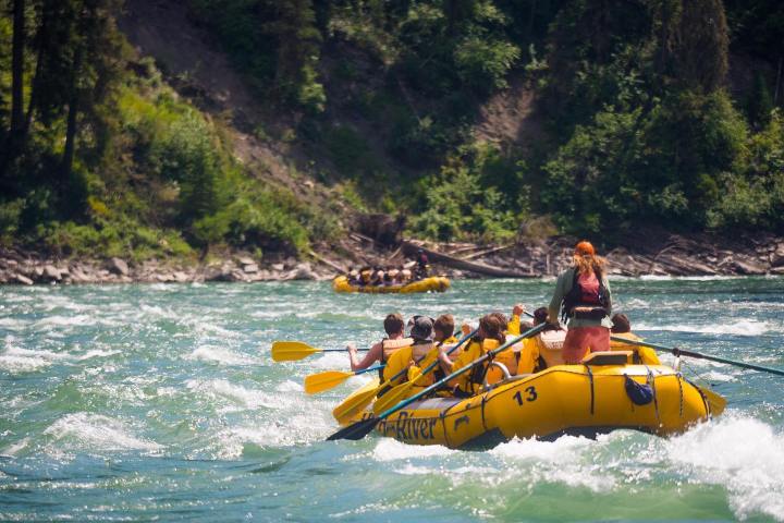 a group of people riding on the back of a boat in the water